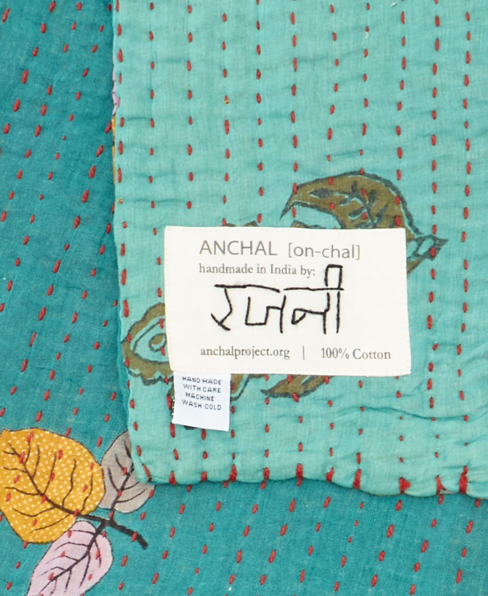small kantha blanket with signature of the maker on the tag