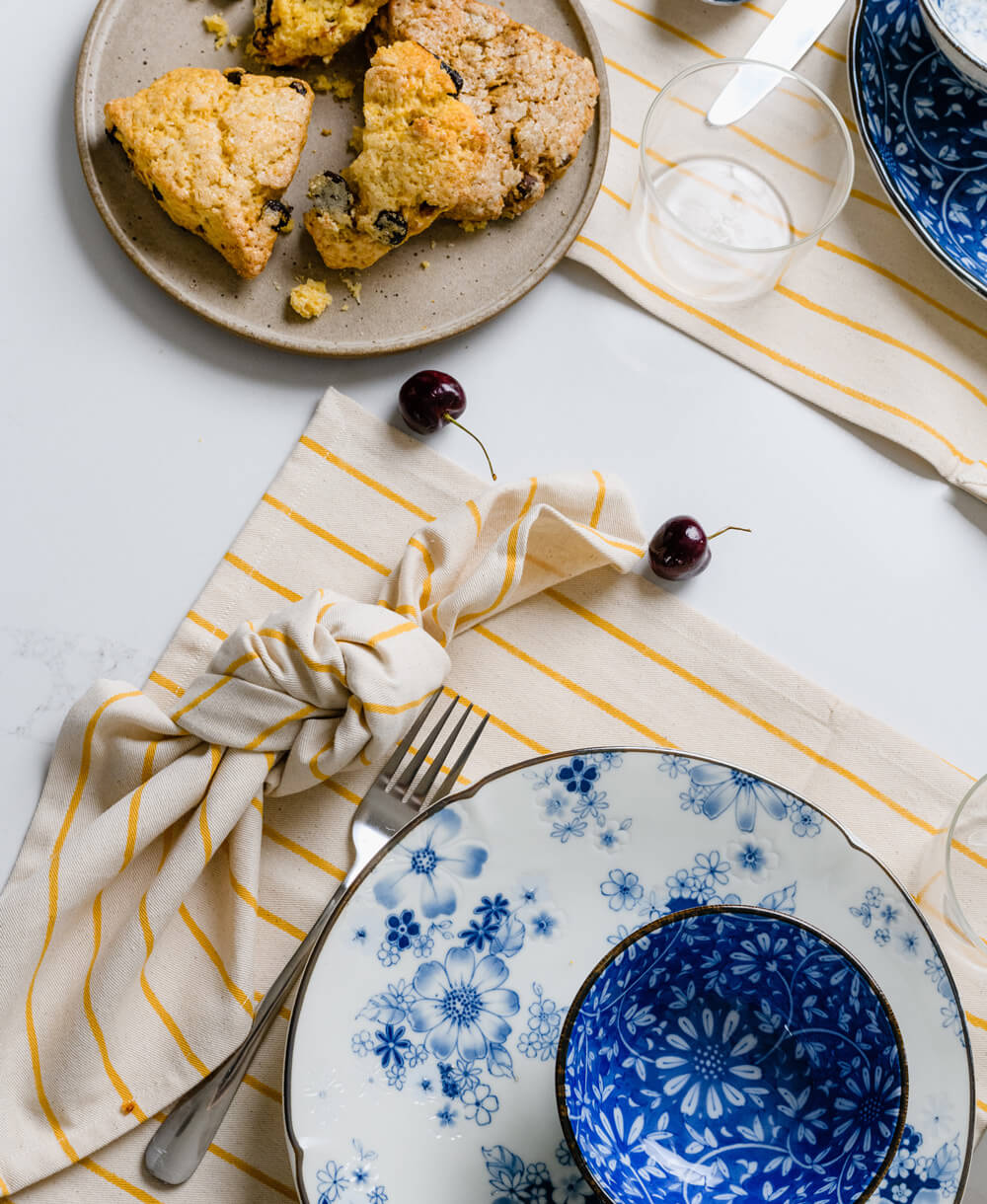 striped mustard yellow block print napkin with matching striped placemat with blue vintage dishes on top