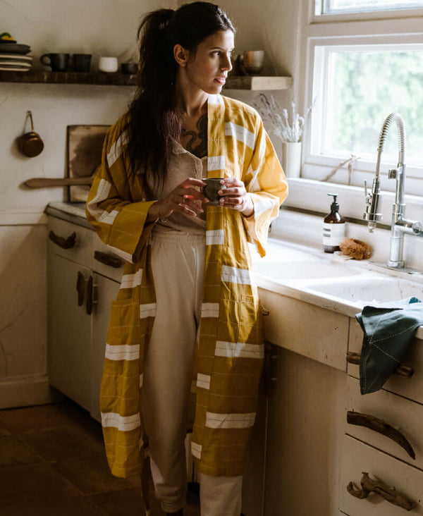 making coffee in organic cotton mustard striped robe handmade in India by Anchal artisans