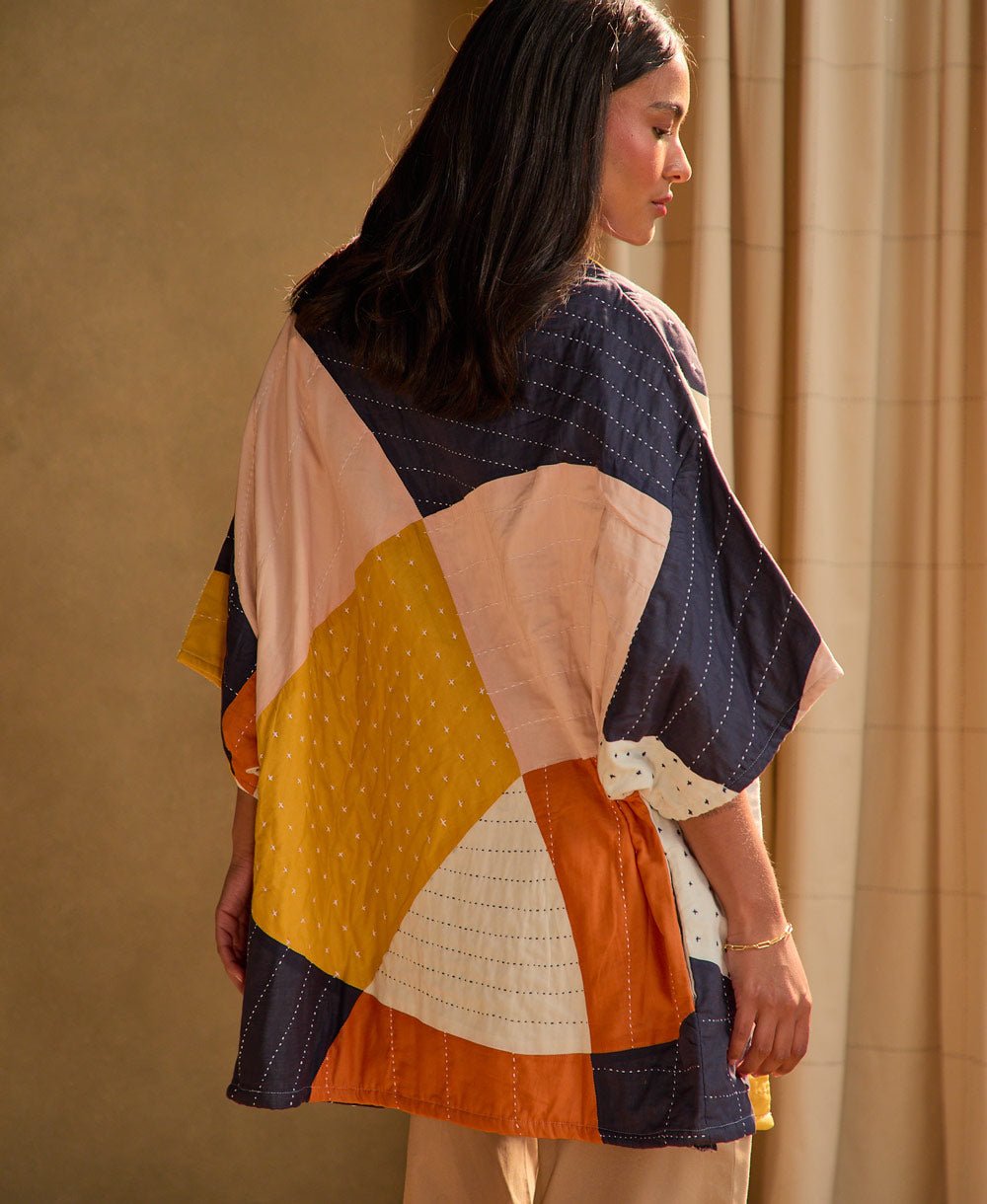 back of woman wearing quilted cocoon jacket in sunset pattern