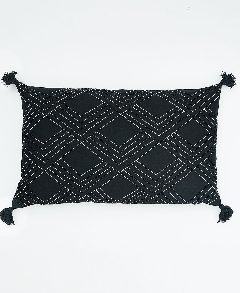 black lumbar pillow with white triangle embroidery and black tassels on each corner made in India