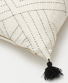 black tassel detail on tilt throw pillow in bone with gold zipper closure