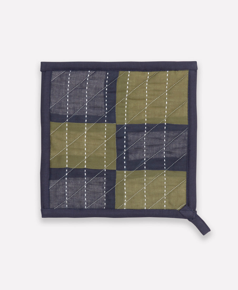 Quilted square hot pad with green and navy checkered pattern on a white background