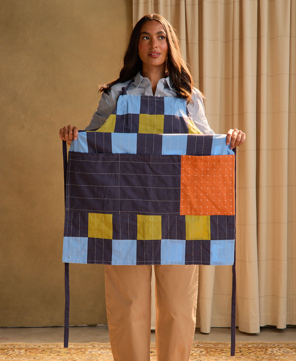 woman putting on a colorful organic bib apron 