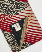 Kantha quilt throw with a tag featuring the hand-stitched signature of the maker