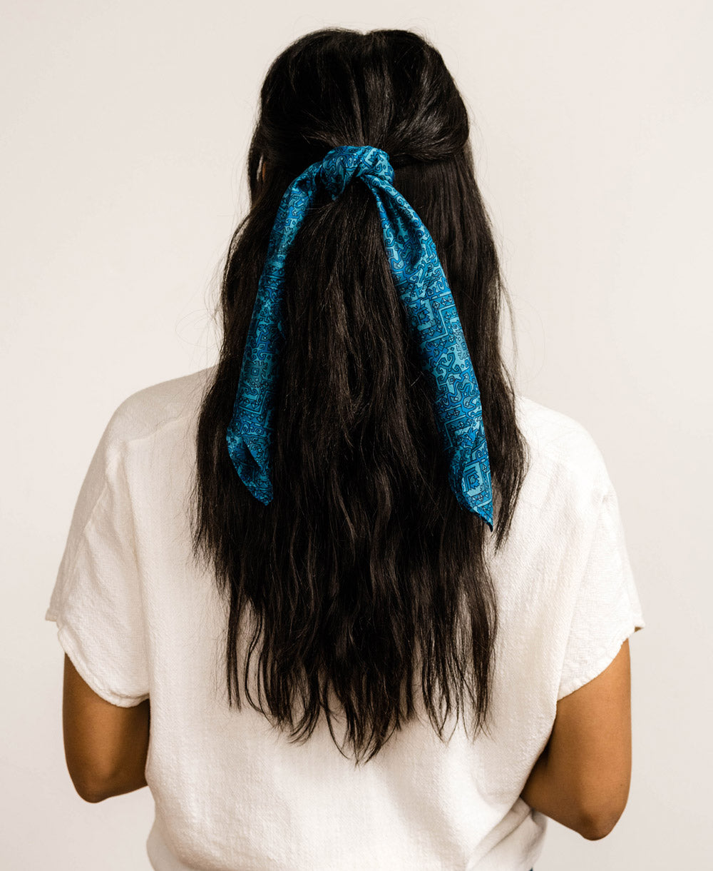 woman wearing a blue vintage silk scarf in her hair  made from repurposed silk saris
