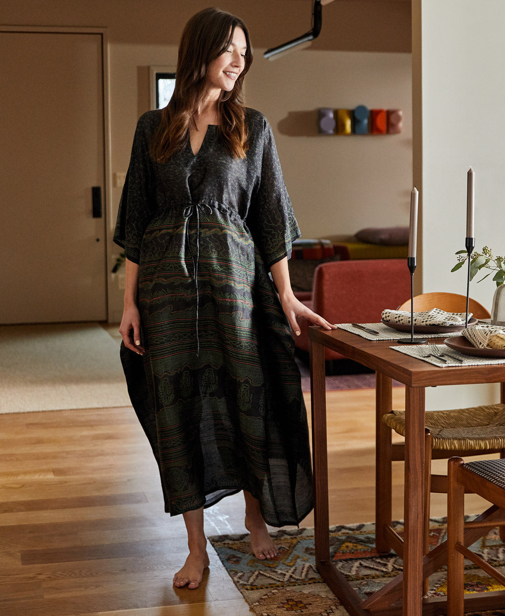 Woman wearing vintage navy silk kaftan dress in her dining room
