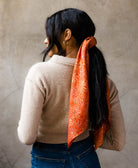 woman wearing orange artisan-made vintage silk square square scarf in her hair