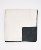 reversible handmade patchwork quilt with bold woven patchwork pattern on front and solid black back