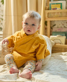 baby girl wearing yellow wrap baby top made from 100% organic cotton with kimono style sleeves