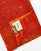 orange kantha quilt throw featuring  the hand stitched signature of the maker 