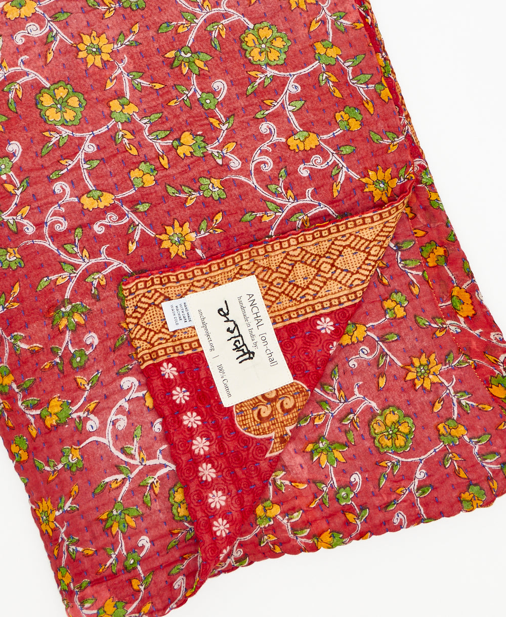 red kantha quilt throw featuring the hand stitched signatre of the maker 