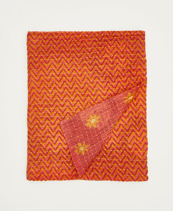 Handmade using repurposed cotton saris, this small throw quilt features yellow traditional kantha hand stitching orange, pink, and red chevron and floral print small cotton quilted throw blanket