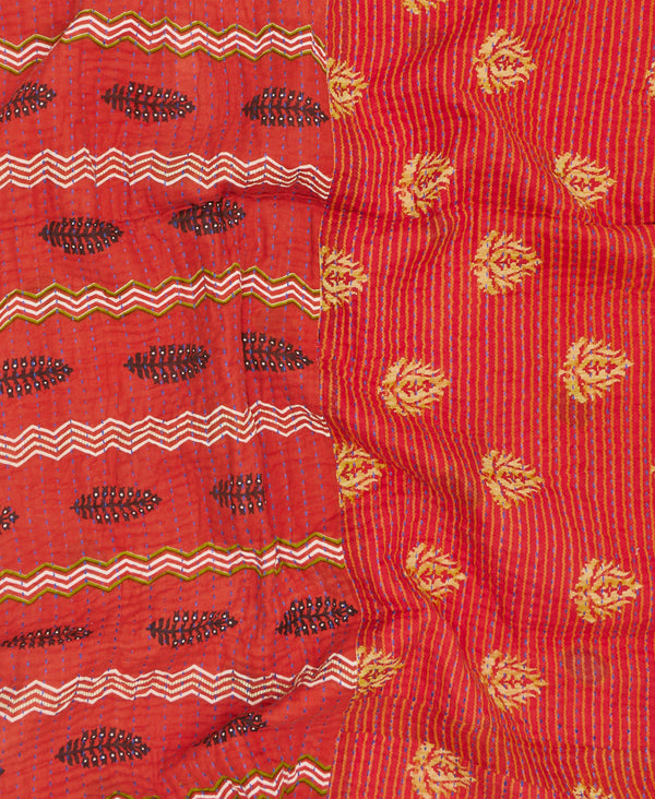Artisan made small red throw quilt featuring contrasting patterns and blue traditional kantha hand stitching 
