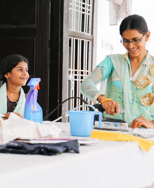 Anchal Project artisan using a steam iron in the Anchal workshop