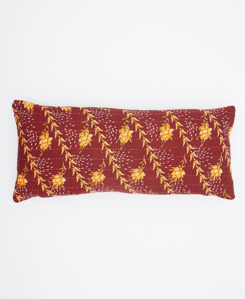 With a burgundy background and a bright yellow floral print this is a skinny lumbar pillow 