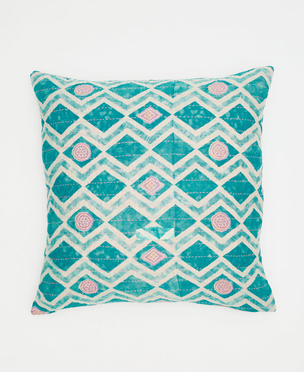 teal and white geometric patterned pillow