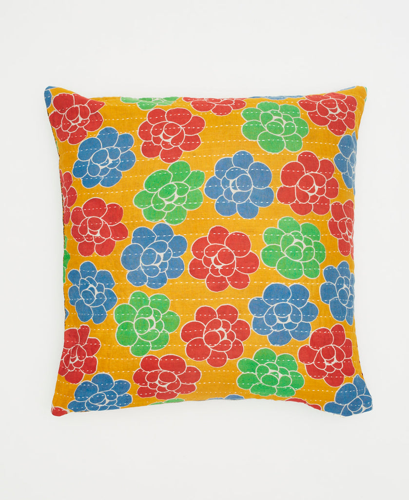 bright orange cotton throw pillow with green, blue, and red flowers and traditional white kantha stitching 
