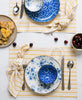 playful brunch tablescape with modern yellow striped placemats and eclectic blue mismatched dishes