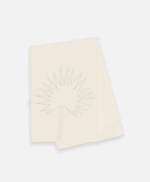 Bone colored organic cotton tea towel folded over to show unique plant design in green stitching 