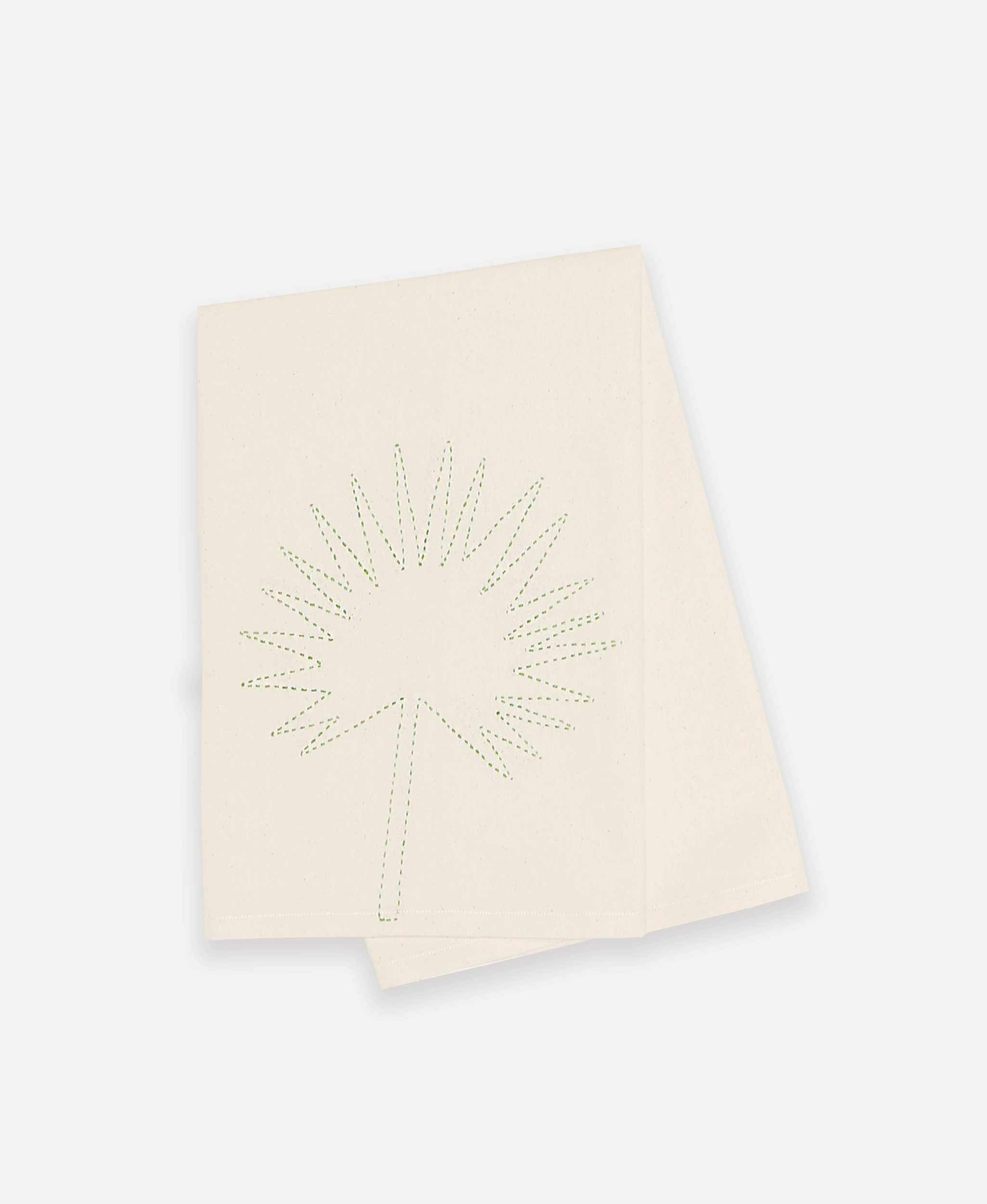 Bone colored organic cotton tea towel folded over to show unique plant design in green stitching 