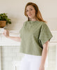 woman with red hair and white jeans wearing Anchal Project's fair trade certified organic cotton crop top