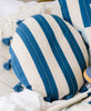 cobalt blue and white striped round shaped throw pillow on all white bed
