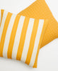 Yellow and white striped modern throw pillow paired with yellow Anchal Project cross-stitch throw pillow
