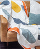 canopy quilt in gumdrop color way draped over mid-century modern sofa