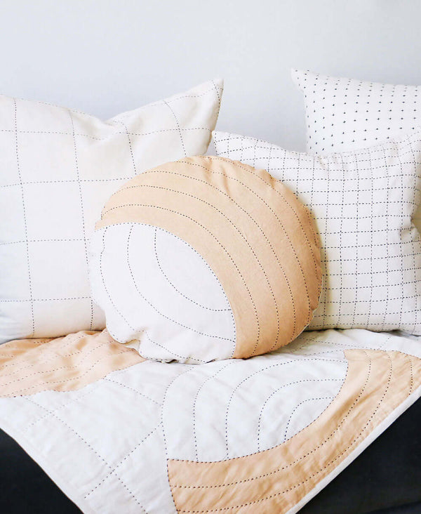 Hand-stitched round throw pillow perfect for mixing and matching with grid-stitched pillows
