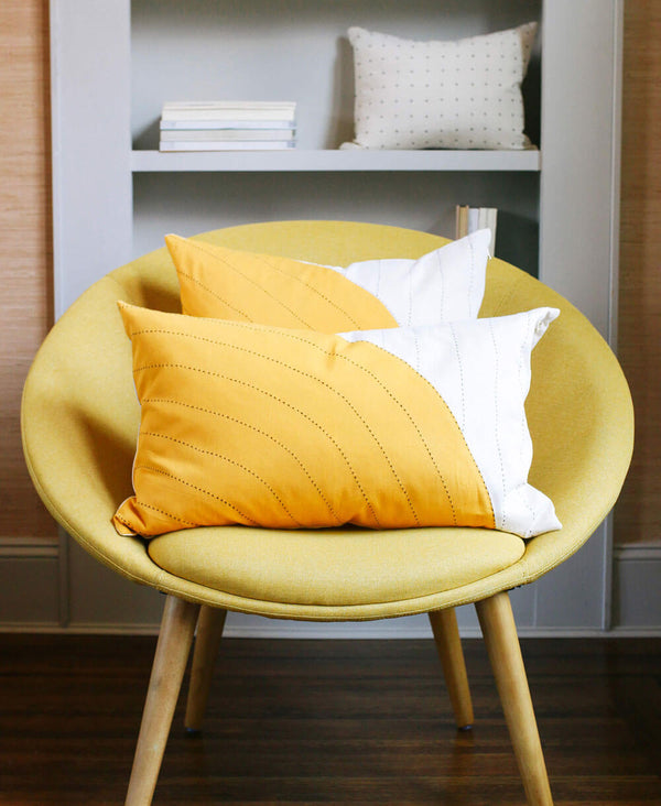 Anchal Project organic cotton gold lumbar pillow in mid-century modern chair