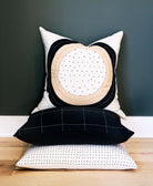 contemporary circle pillow stacked on top of hand embroidered pillows