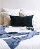 Geometric black and white pillows styled together on bedding with a kantha colorblock quilt