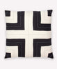 Cream and black throw pillow with cross design in middle