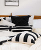 black and white modern bed featuring Anchal Project's interlock throw pillow in charcoal black