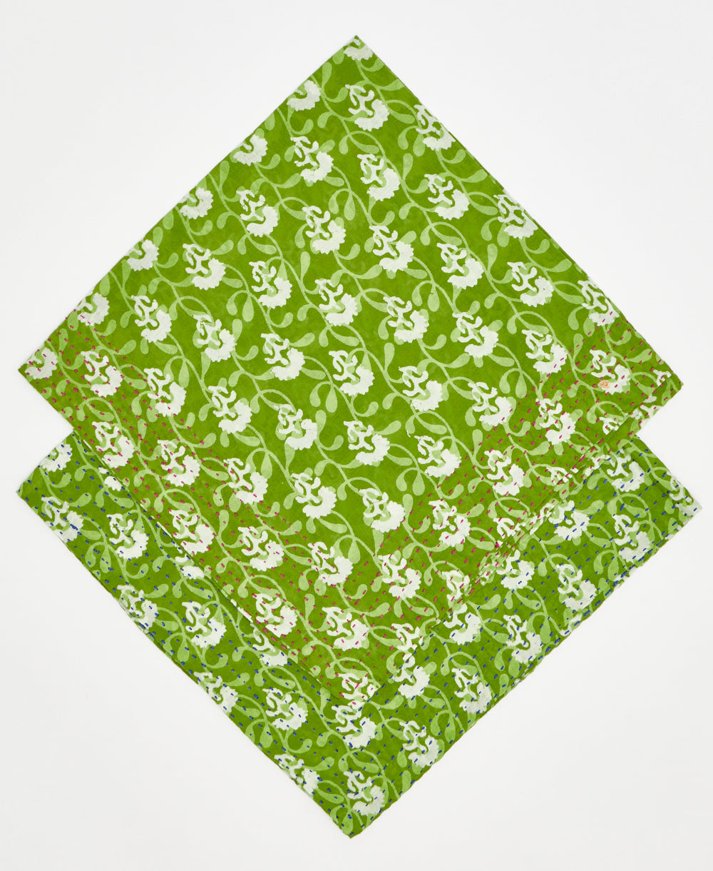 two green and white floral bandanas stacked on top of each other to show their different thread colors. one has red kantha stitching along its edges while the other has blue stitching 