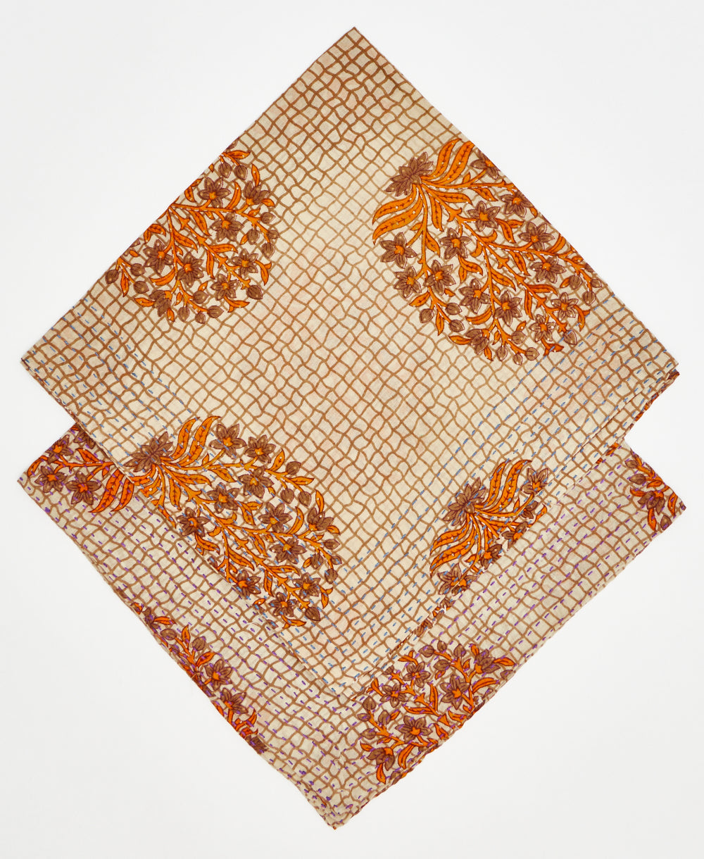 two beige bandanas stacked on top of each other; one with blue kantha stitching and the other with purple kantha stitching 