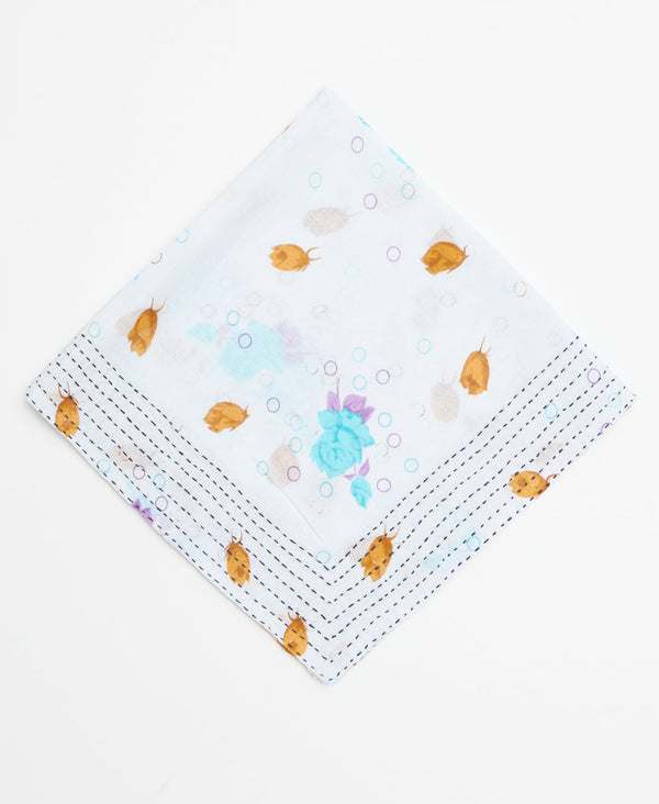 White bandana featuring a minimal yellow, blue, and purple floral pattern and kantha stitching 
