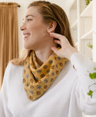 woman in white sweater smiling while wearing a yellow vintage kantha bandana from Anchal tied around her neck