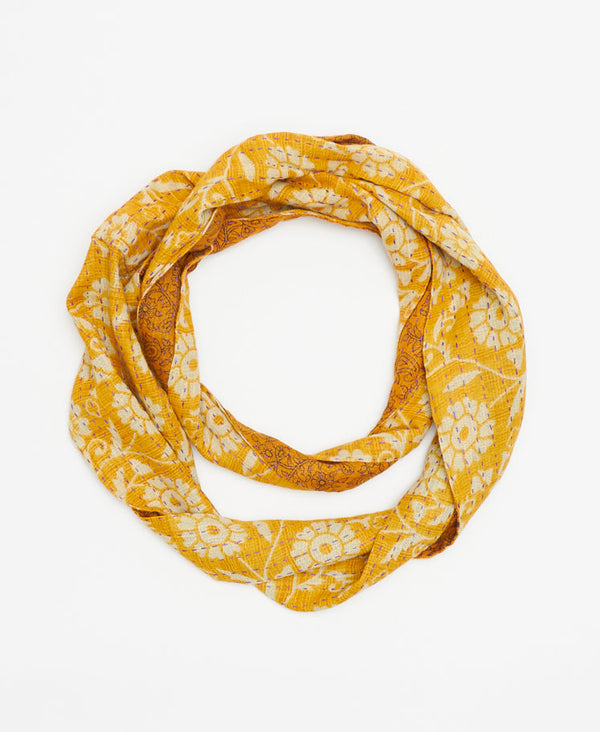 gold infinity scarf hand-made by a woman artisan features a tag with the signature of its maker