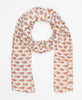 White spring time inspired cotton scarf that has orange and pink patterning 