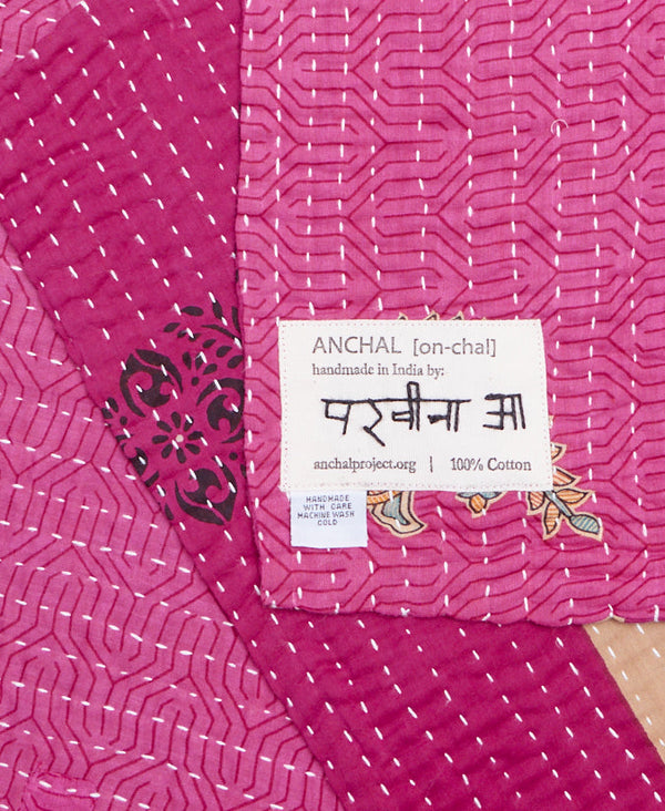 Tag featuring the hand-stitched signature of the maker 