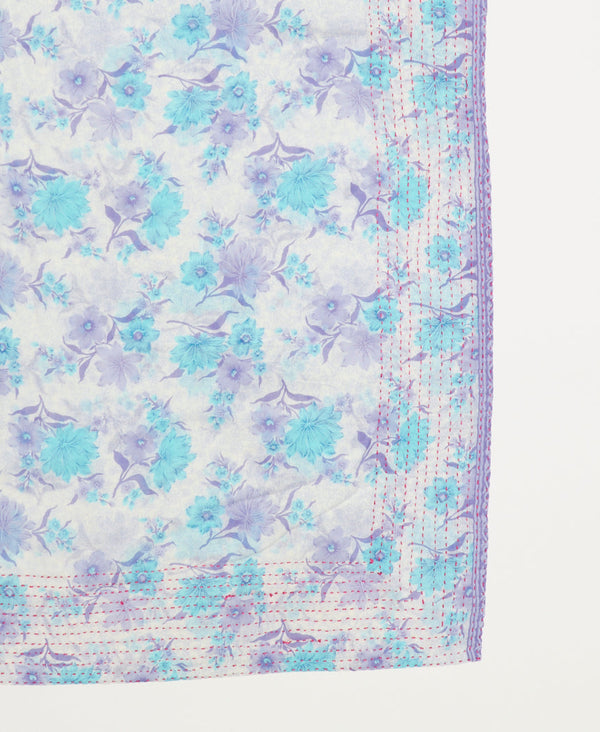 bright blue and lavender flowers on a light white background with red traditional kantha stitching along the edges of the soft cotton square scarf 