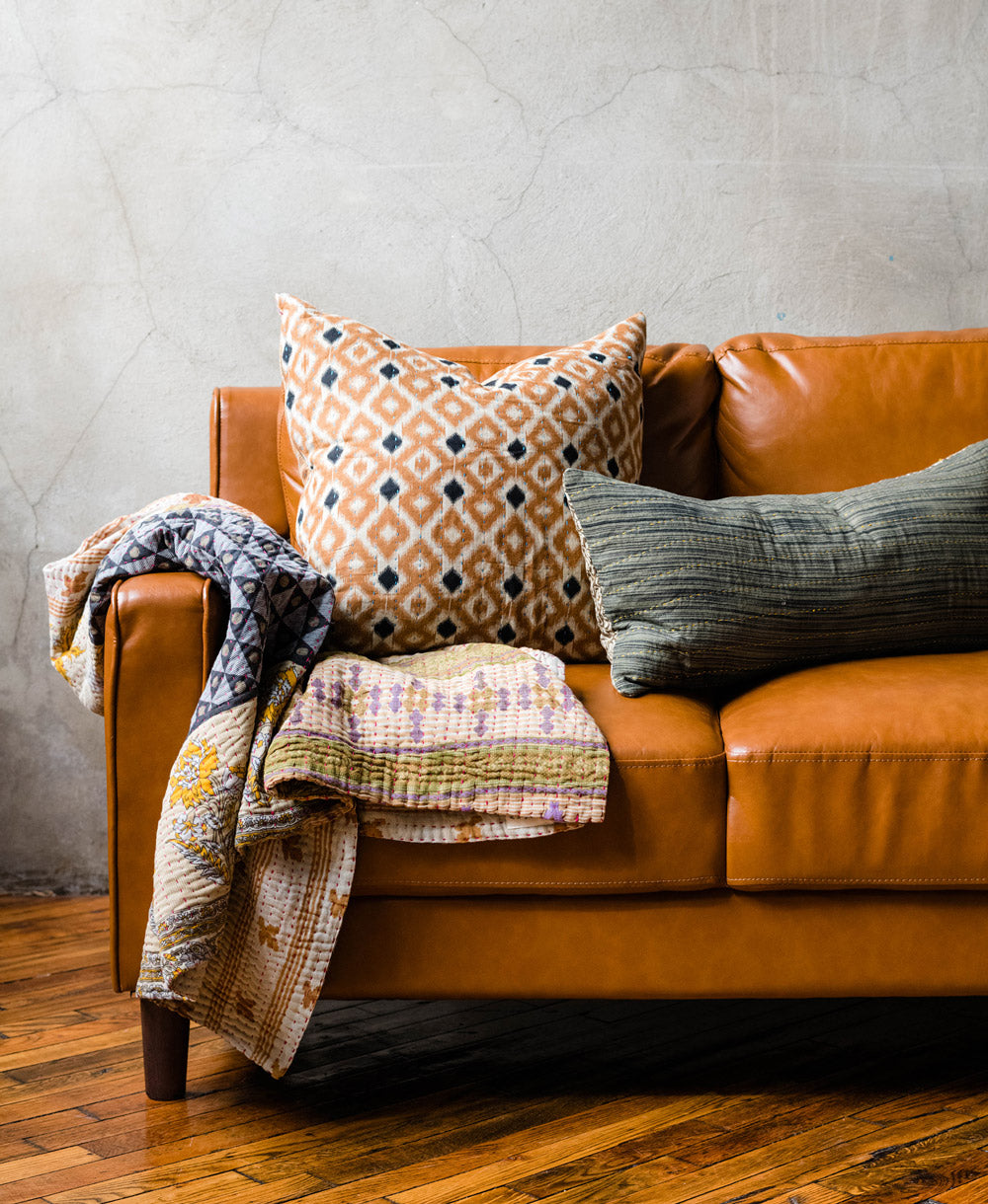 Anchal vintage kantha pillows and quilts on a brown leather couch