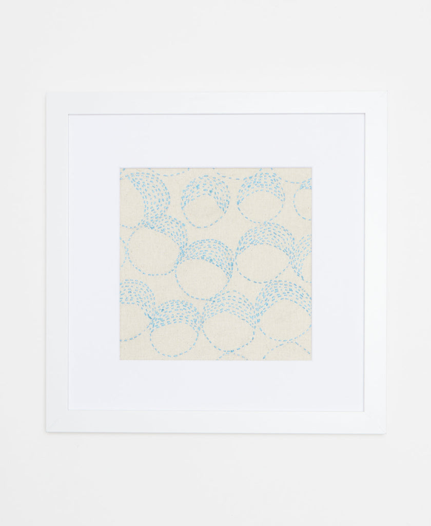 Handcrafted artisan-made framed artwork featuring light blue circular stitching on a white background  