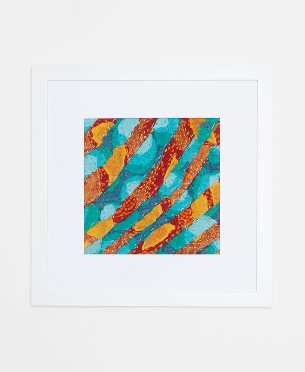 Handcrafted artisan-made framed textile art featuring a bold orange, blue, and yellow design
