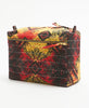 black cotton toiletry bag with bright red and yellow geometric accents and a gold toned zipper