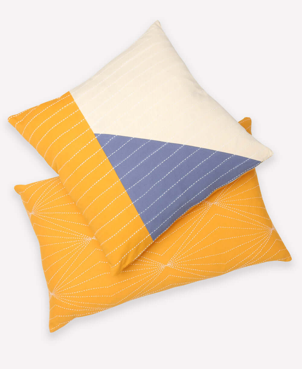 hand-embroidered modern throw pillows in mustard yellow and slate blue patchwork