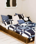 navy blue plaid quilt on rustic platform bed in modernist home