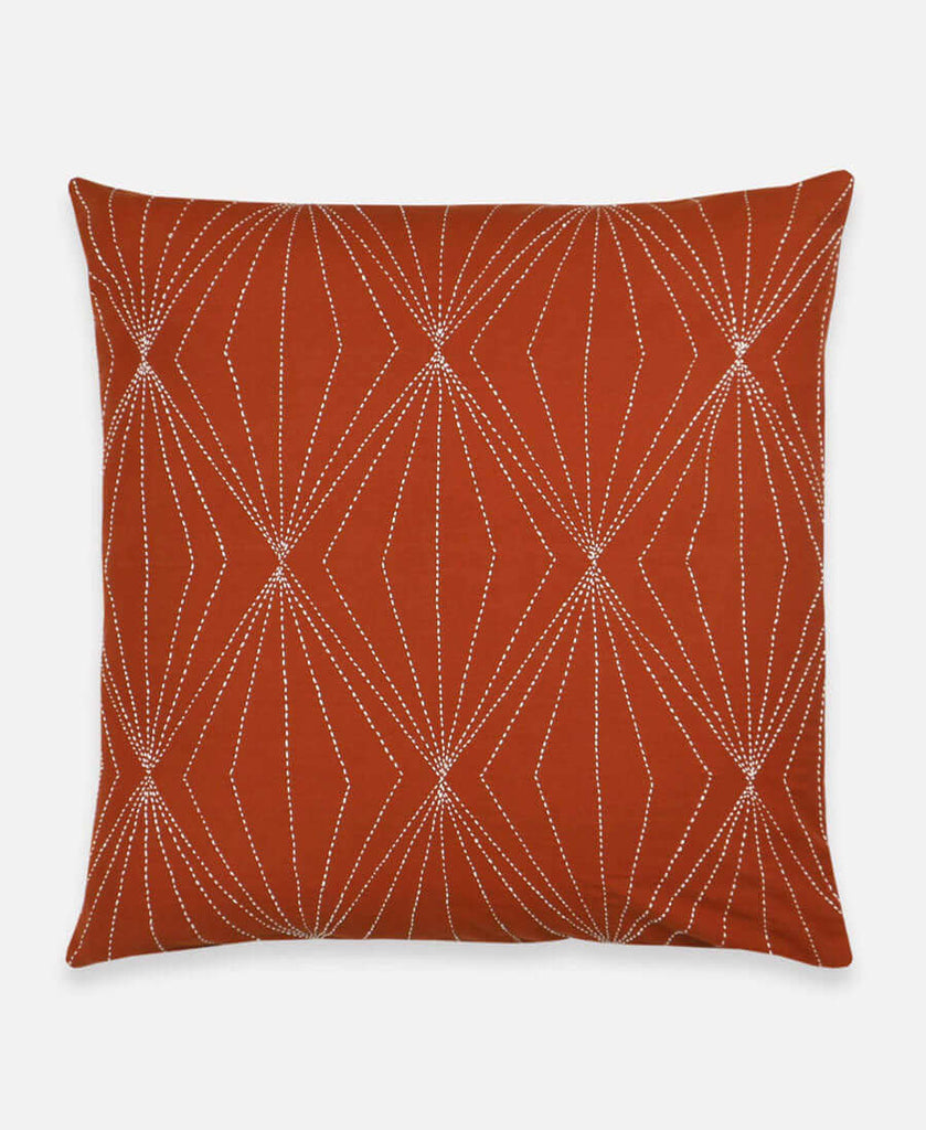 Rust orange throw pillow with hand-embroidered geometric diamond design